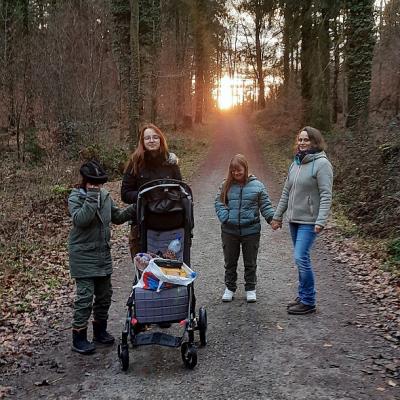 Vier Personen stehen auf einem Weg im Wald.