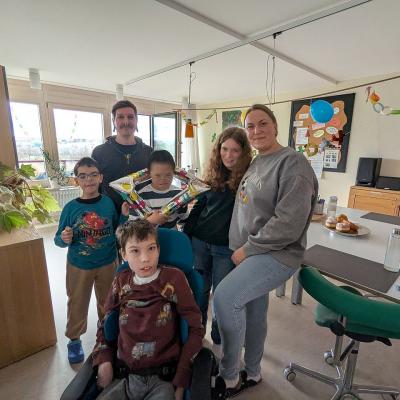Gruppenbild: Ein Mann und eine Frau mit 4 Schülern schauen lachend in die Kamera. 