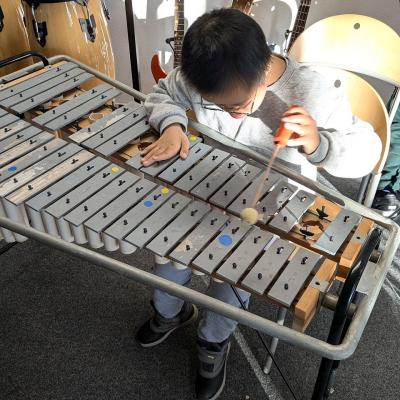 Ein Junge sitzt am Glockenspiel und spielt