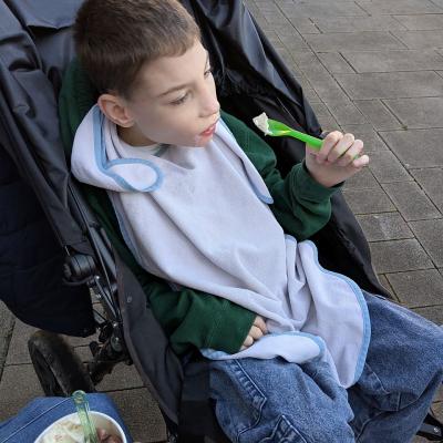 Ein junger Mann sitzt in einem Buggy und isst ein Eis.