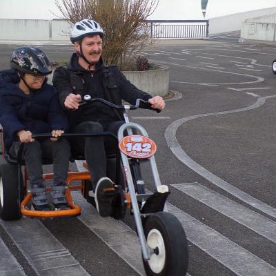 Ein mann und ein Junge fahren in einem Doppelkettcar zusammen und lachen.