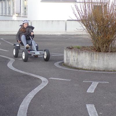 Ein Mädchen fährt schnell mit dem kettcar um die Kurve.