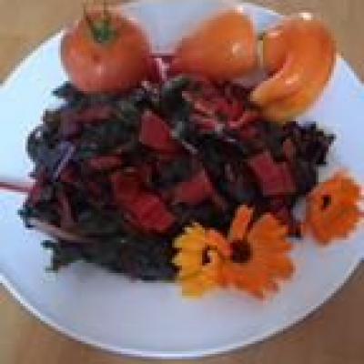 Frisch zubereiteter Mangold und Tomaten auf einem weißen Teller, dekoriert mit Blumen