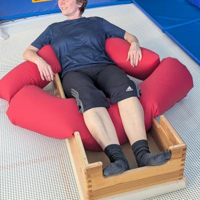 Eine Frau ist in einem Kasten auf dem Trampolin gelagert