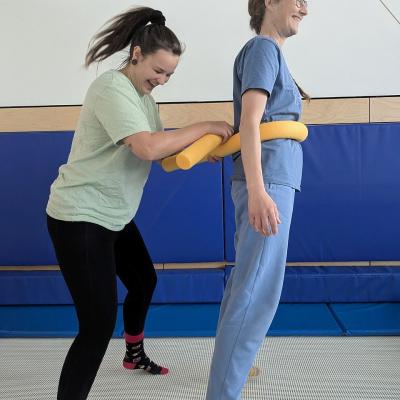 zwei Frauen springen auf dem Trampolin und lachen