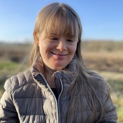 Eine junge Frau lächelt in die Kamera