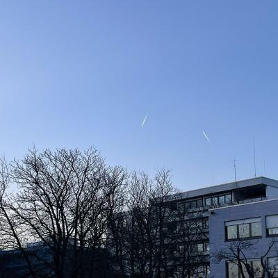 Am blauen Himmel sieht man Kondenzstreifen von Flugzeugen