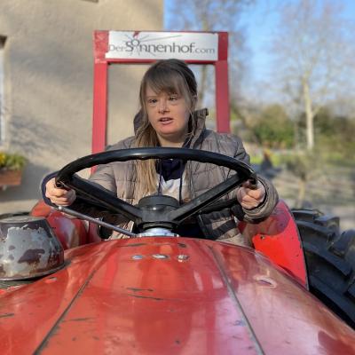 Eine junge Frau sitzt auf einem Traktor