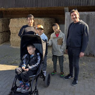 Ein Gruppenbild mit drei Jungs einem Mann und einer Frau, alle lachen in die Kamera