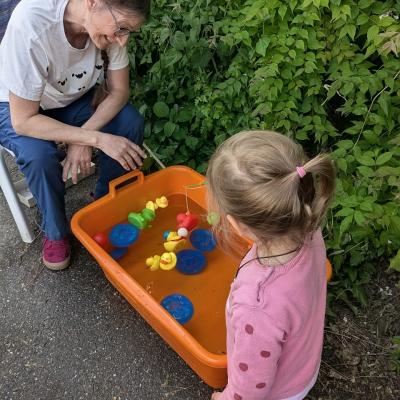 Eine Frau und ein kleines Mädchen stehen am Entenangelbecken