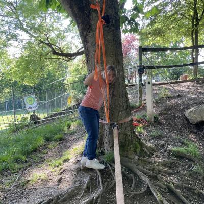 Eine junge Frau steht an einer Slackline