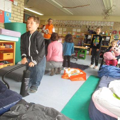 Ein Klassenzimmer der AHWS, im Vordergrund ein 9jähriger Junge, der seine Luftmatratze aufpumpt, im Hintergrund 2 Erwachsene und 3 Mädchen