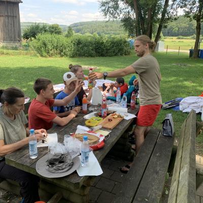Nach der Kanutour essen die Teilnehmer an dem Rastplatz.