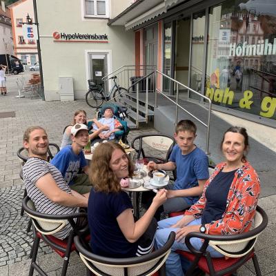 Die Gruppe sitzt in Eichstätt am Marktplatz um einen Tisch. Sie essen Eis.